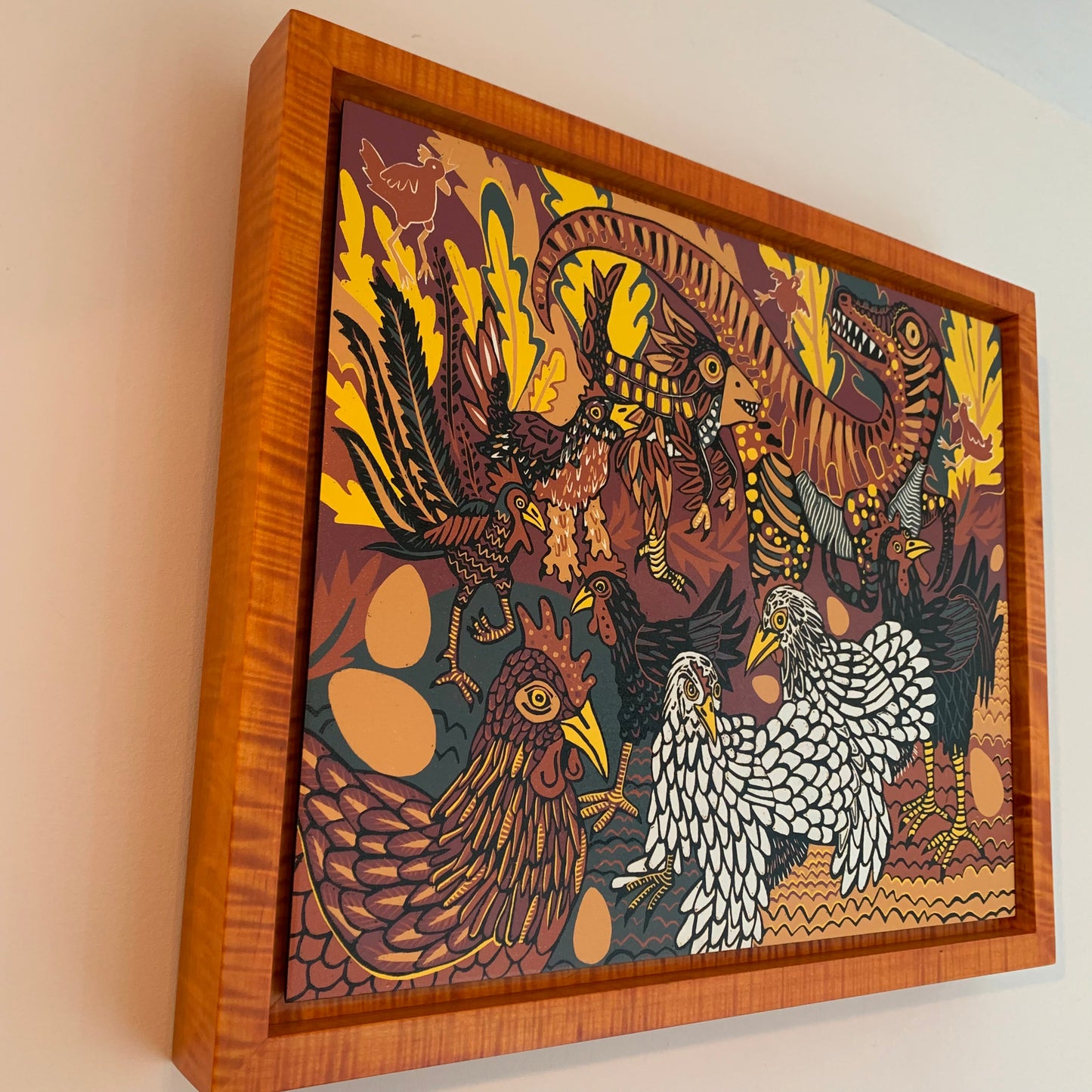 Evolution of chickens woodcut framed in orange curly maple