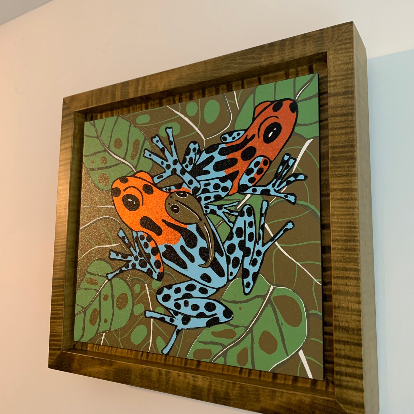 Dart frog woodcut framed in olive green solid tiger maple wood
