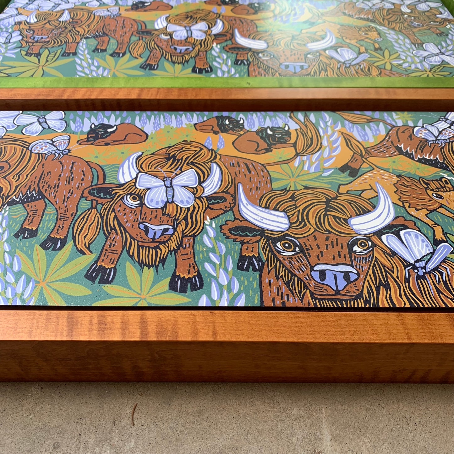 Bison and butterflies woodcut framed in natural curly maple